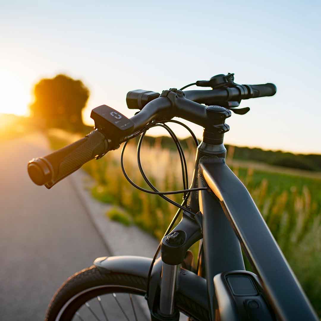 Vorderrad und Lenker eines Fahrrads in der Abendsonne