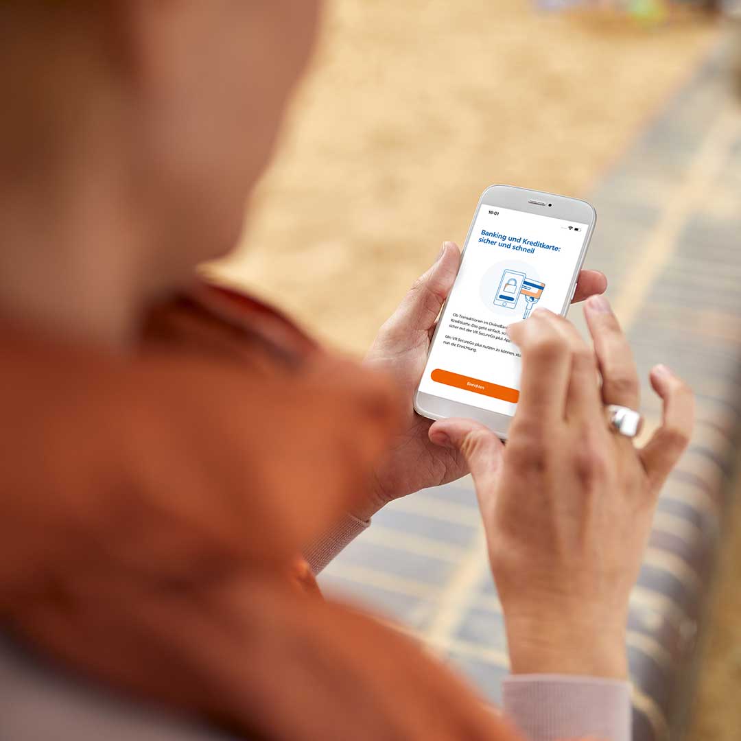 Frau hält Smartphone mit geöffneter VR Secure Go Plus App.